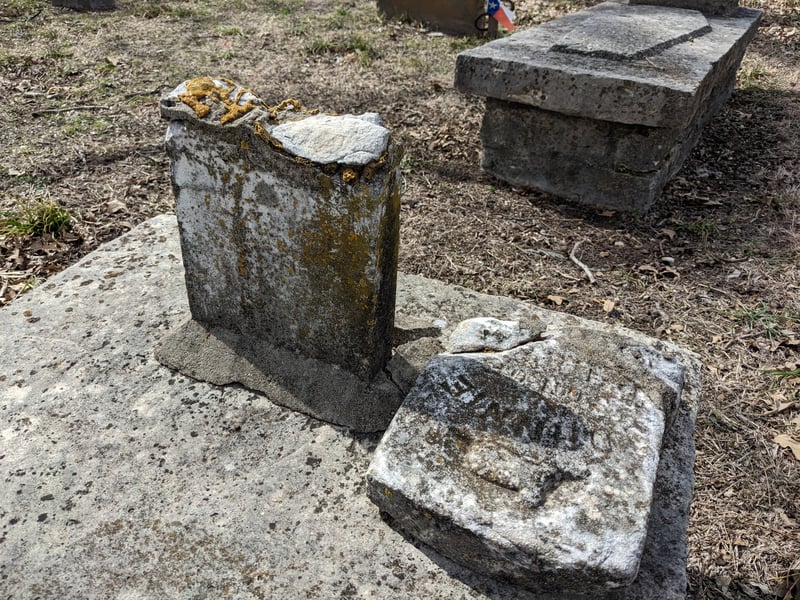 Broken historic gravestones with irregular weathering and lichen