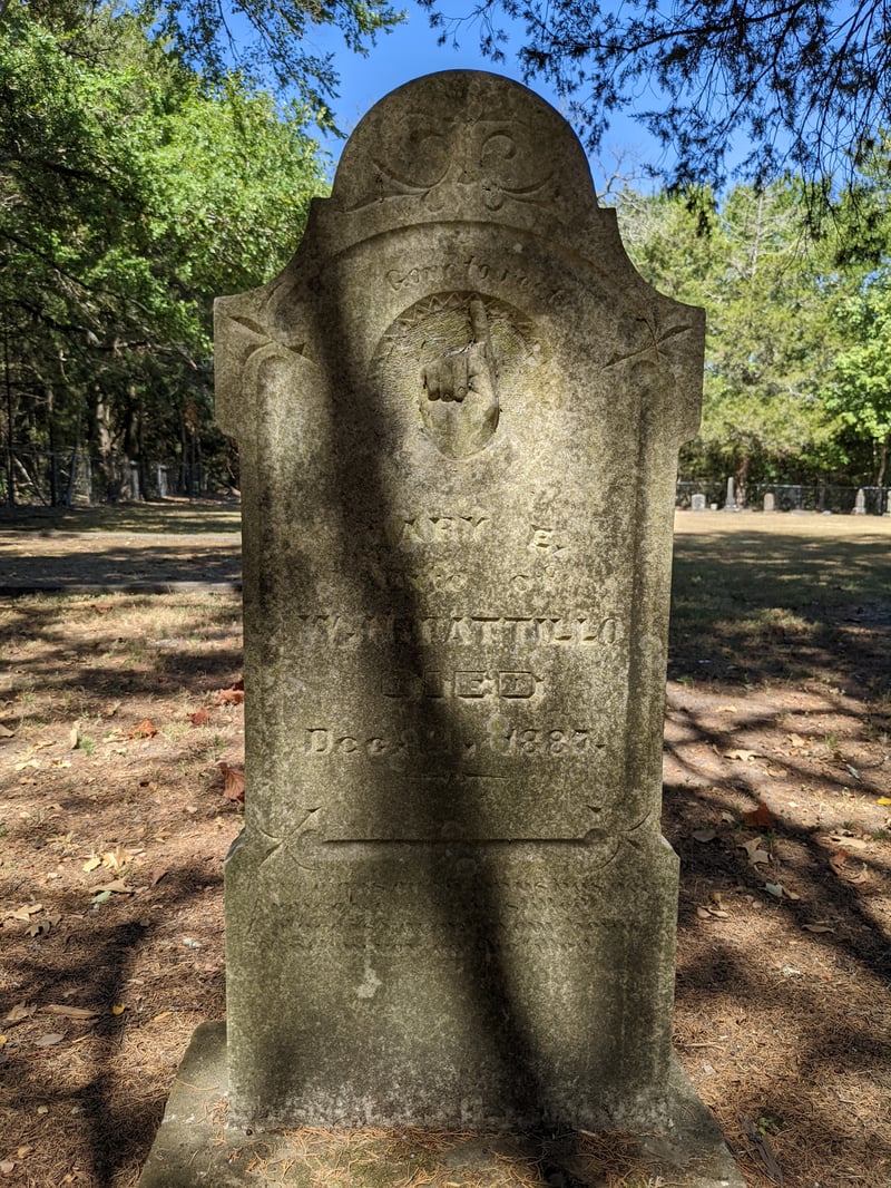 Historic gravestone with a carved pointing-up hand symbol
